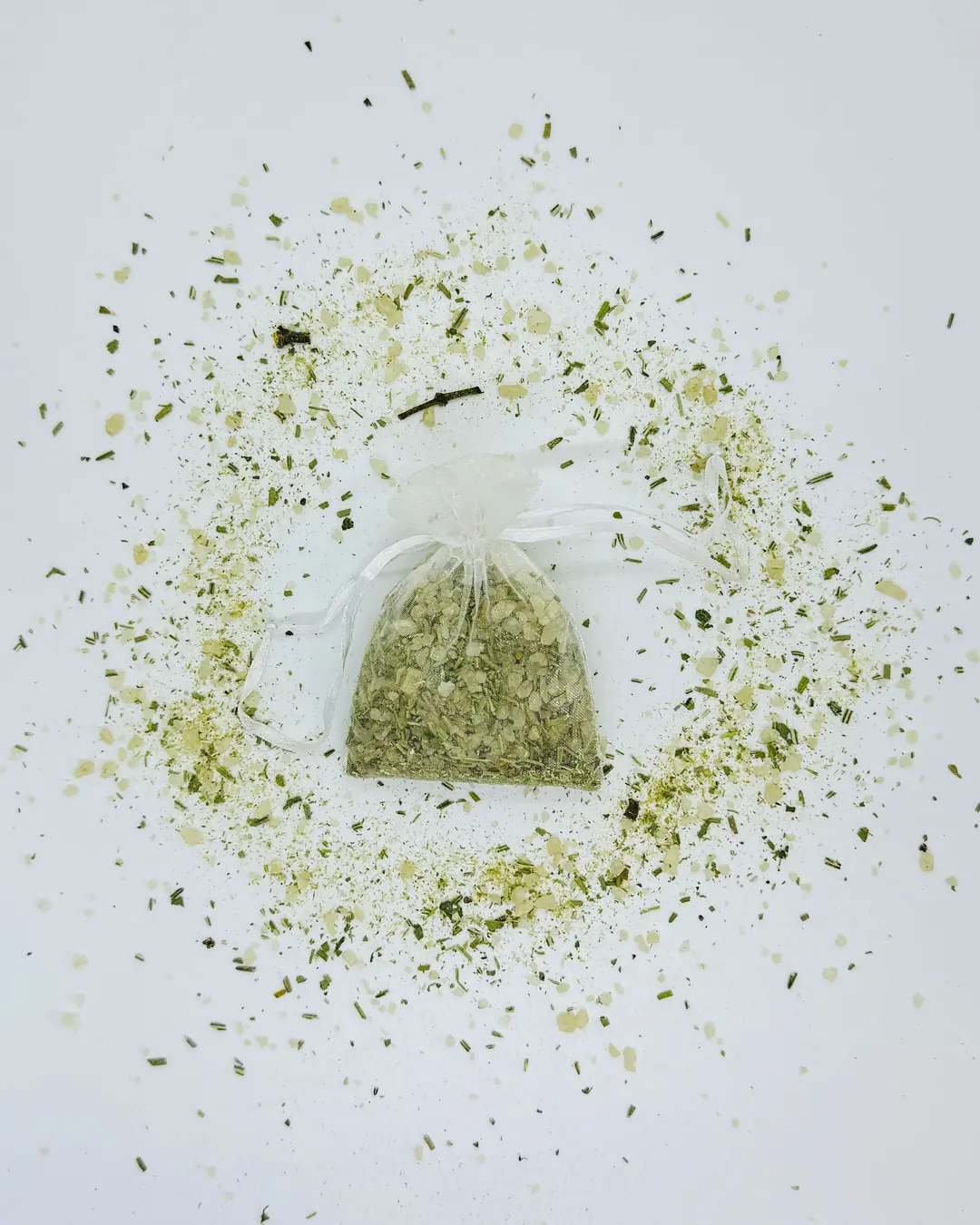 Costal de organza con sal de grano y hierba seca, rodeado de un círculo de la misma mezcla.